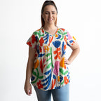 Woman wearing a colorful light cotton pintuck floral blouse 