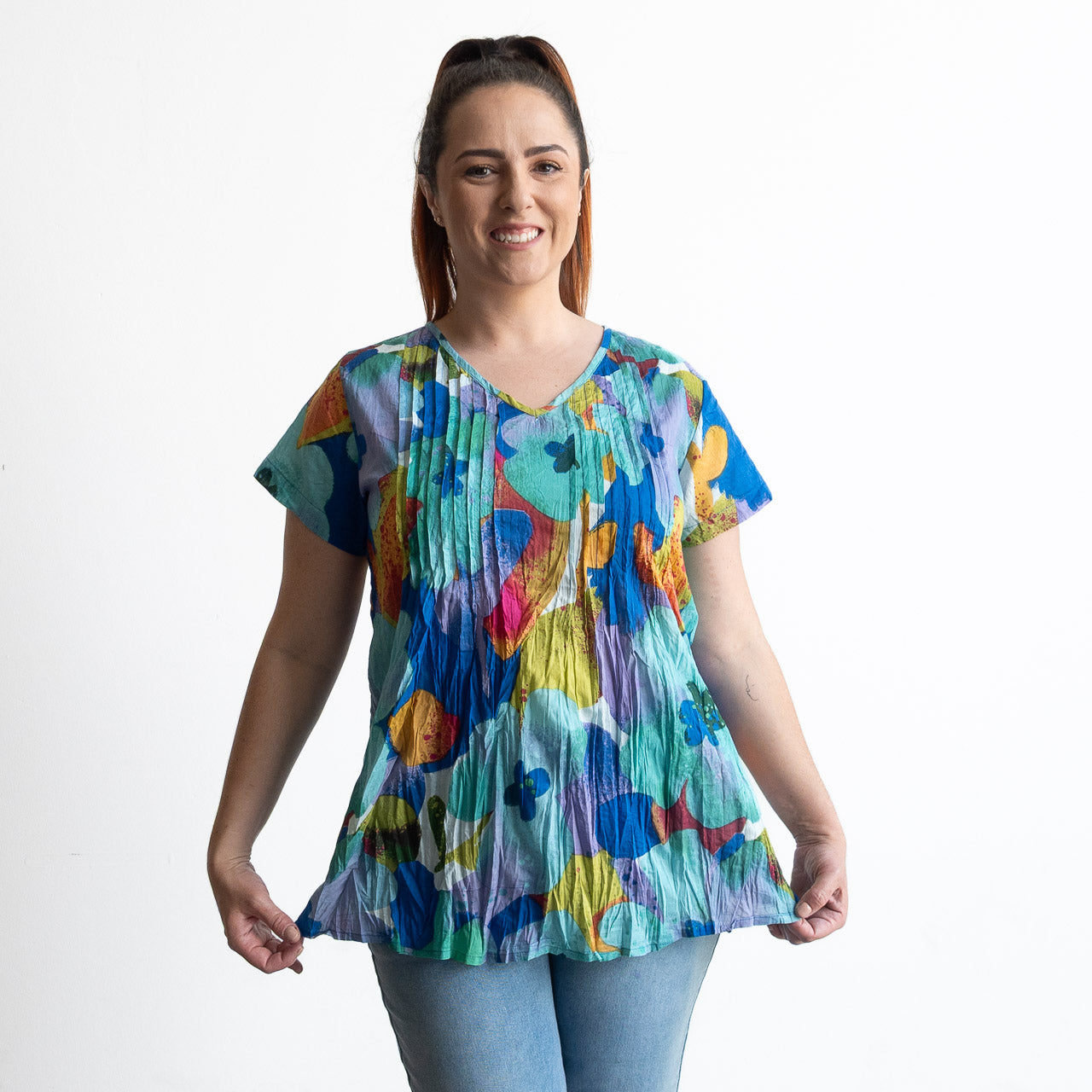 Woman wearing turquoise blue watercolour flora top in light crinkle cotton