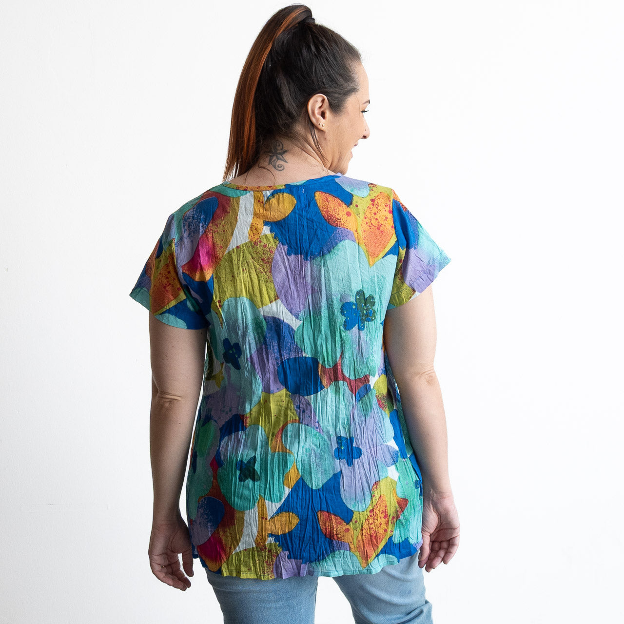 Woman wearing turquoise blue watercolour floral top in light crinkle cotton