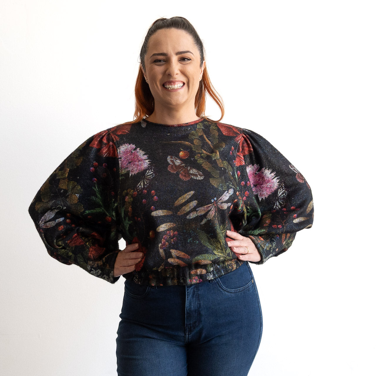 Woman wearing a floral blouse with puffed sleeves on a white background