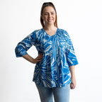 Woman wearing a blue and white leaf patterned light cotton blouse 