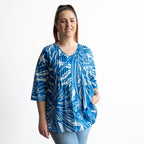 Woman wearing a blue and white leaf patterned light cotton blouse 