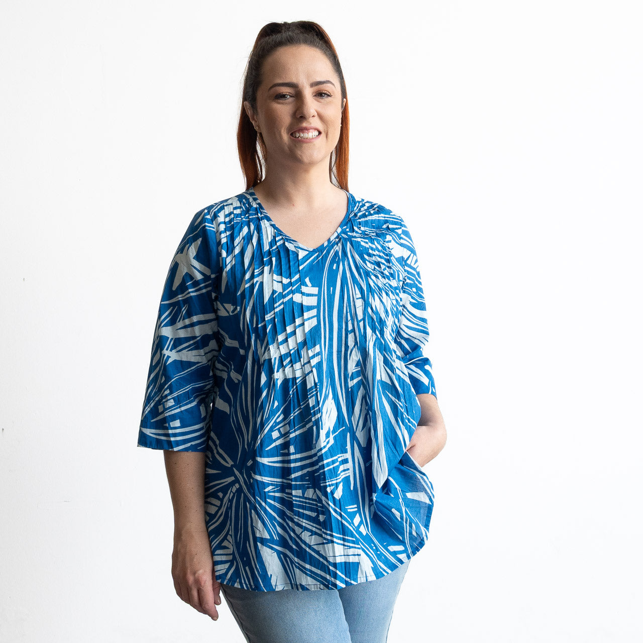 Woman wearing a blue and white leaf patterned light cotton blouse 