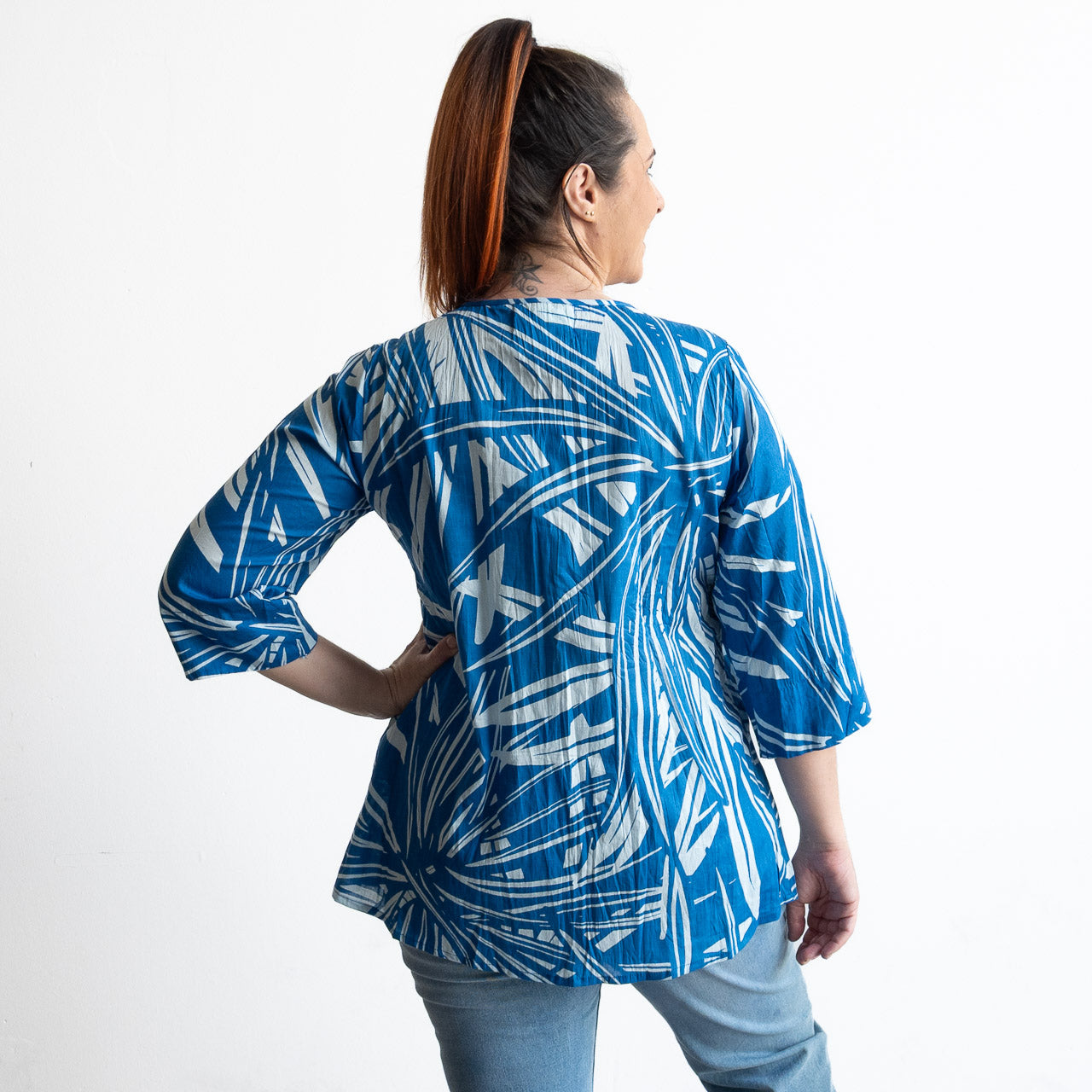 Woman wearing a blue and white leaf patterned light cotton blouse 