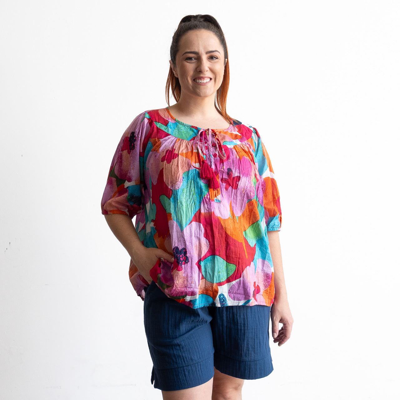 Woman wearing a colorful artwork floral light cotton blouse