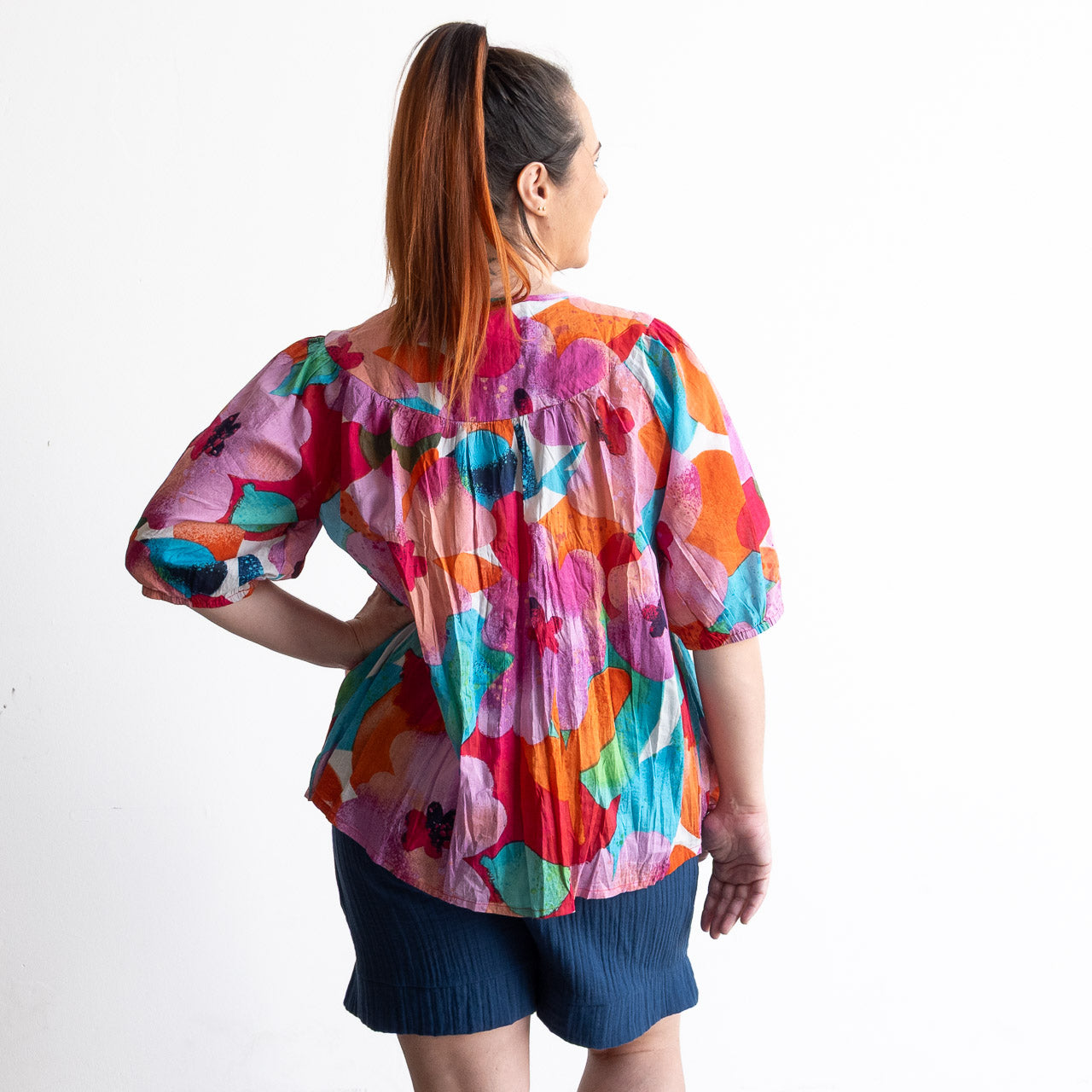 Woman wearing a colorful artwork floral light cotton blouse