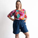 Woman wearing a colorful artwork floral light cotton blouse