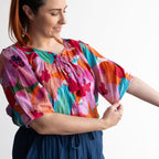Woman wearing a colorful artwork floral light cotton blouse