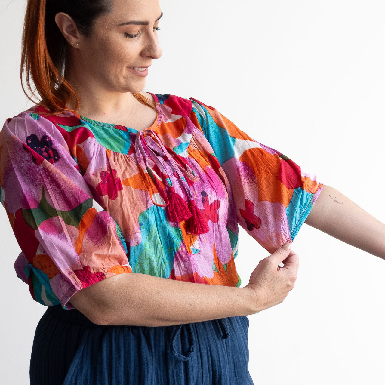 Woman wearing a colorful artwork floral light cotton blouse