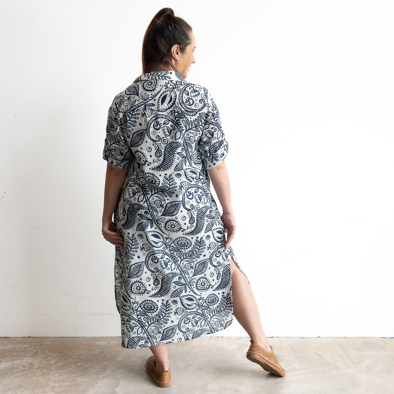 Button-through classic cotton shirt dress in navy and white illustrated botanical print. Midi length hemline.