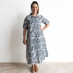Button-through classic cotton shirt dress in navy and white illustrated botanical print. Midi length hemline.