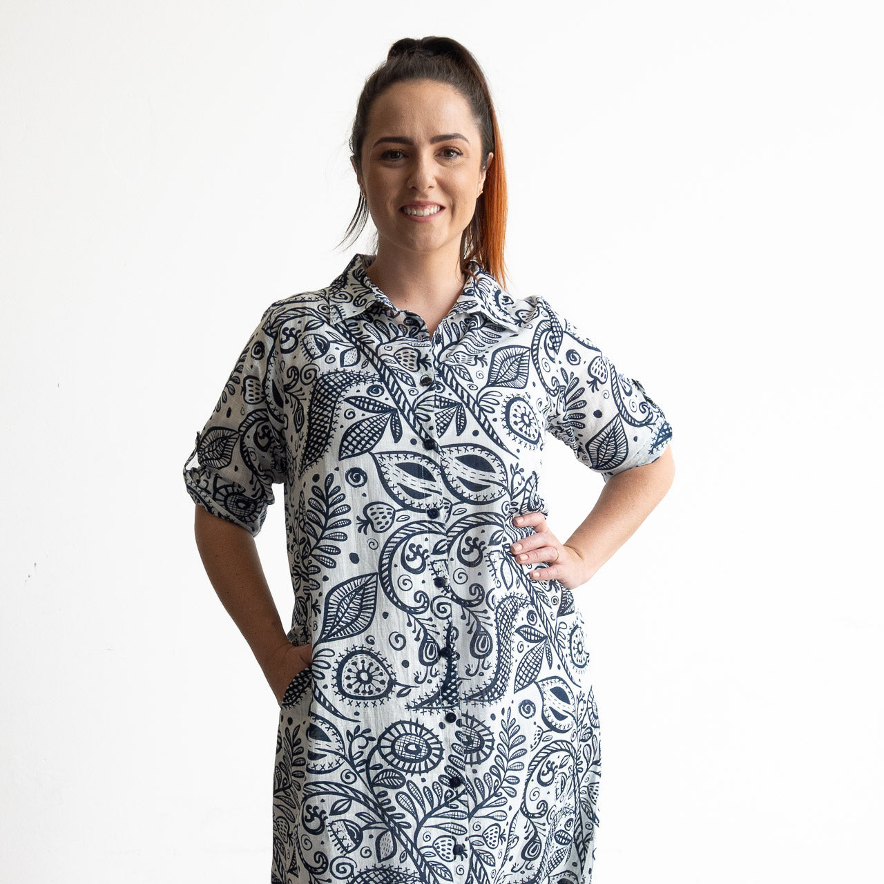 Button-through classic cotton shirt dress in navy and white illustrated botanical print. Midi length hemline.