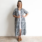 Button-through classic cotton shirt dress in navy and white illustrated botanical print. Midi length hemline.