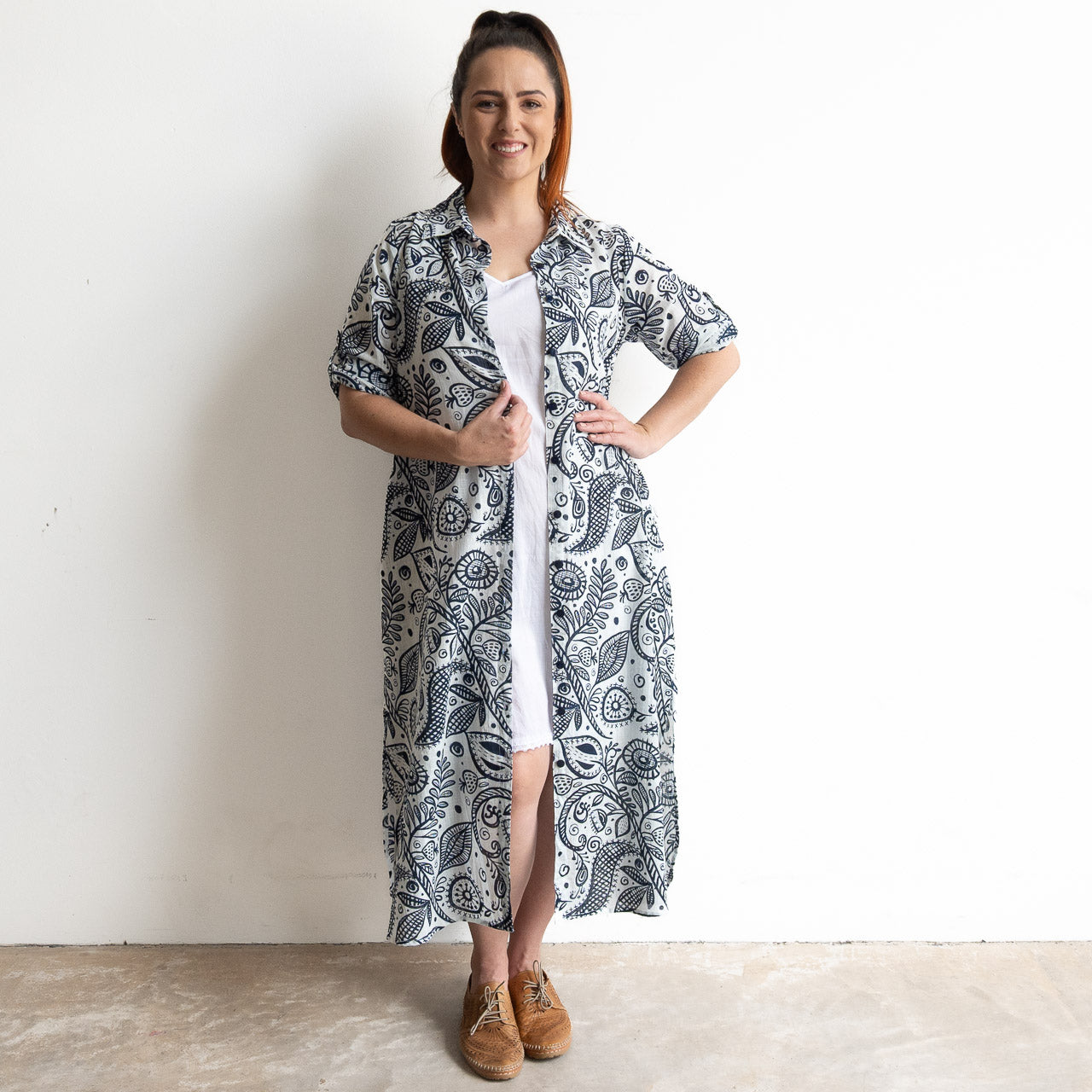 Button-through classic cotton shirt dress in navy and white illustrated botanical print. Midi length hemline.