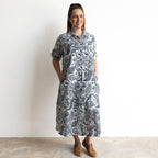 Button-through classic collared cotton shirt dress in navy and white illustrated botanical print. Midi length hemline.