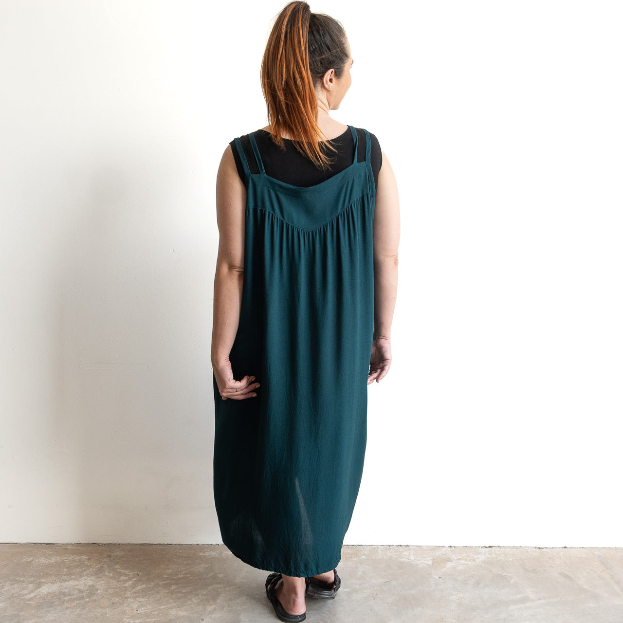 Shoestring midi sundress in a loose style in peacock green layered over a black bamboo tshirt