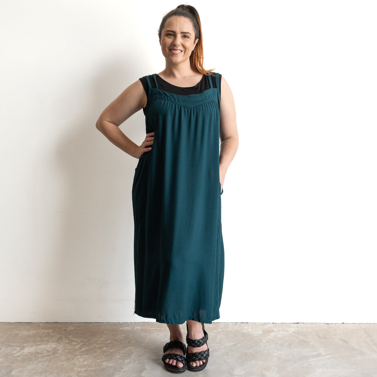 Shoestring midi sundress in a loose style in peacock green layered over a black bamboo tshirt