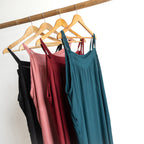 Shoestring midi sundress colour range hanging on a bamboo pole.