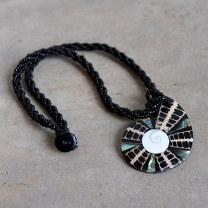 By The Sea Shore Necklace made with mother-of-pearl and glass beads in a tortoise shell pattern. Shell-Black.