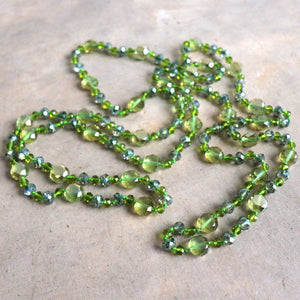 Stunning luxe-length, hand-knotted necklace made with faceted glass beads in a rainbow metallic finish. Apple Green.