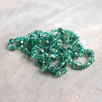 Stunning luxe-length, hand-knotted necklace made with faceted glass beads in a rainbow metallic finish. Emerald Green.
