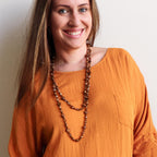 Stunning luxe-length, hand-knotted necklace made with faceted glass beads in a rainbow metallic finish. Gold.