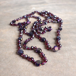 Stunning luxe-length, hand-knotted necklace made with faceted glass beads in a rainbow metallic finish. Plum Purple.