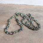 Stunning luxe-length, hand-knotted necklace made with faceted glass beads in a rainbow metallic finish. Sage Green.