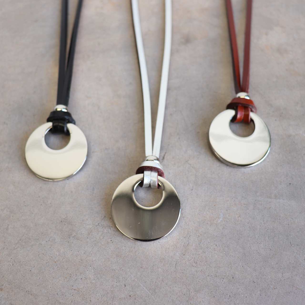 Silver Moon-shaped pendant combined with a natural leather band, available in 3 colours, Black, Silver and Tan.