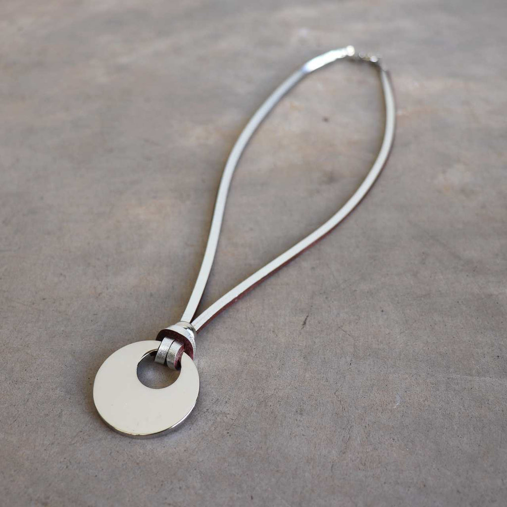 Silver Moon-shaped pendant combined with a natural leather band, available in 3 colours, Black, Silver and Tan.