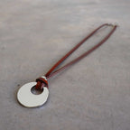 Silver Moon-shaped pendant combined with a natural leather band, available in 3 colours, Black, Silver and Tan.
