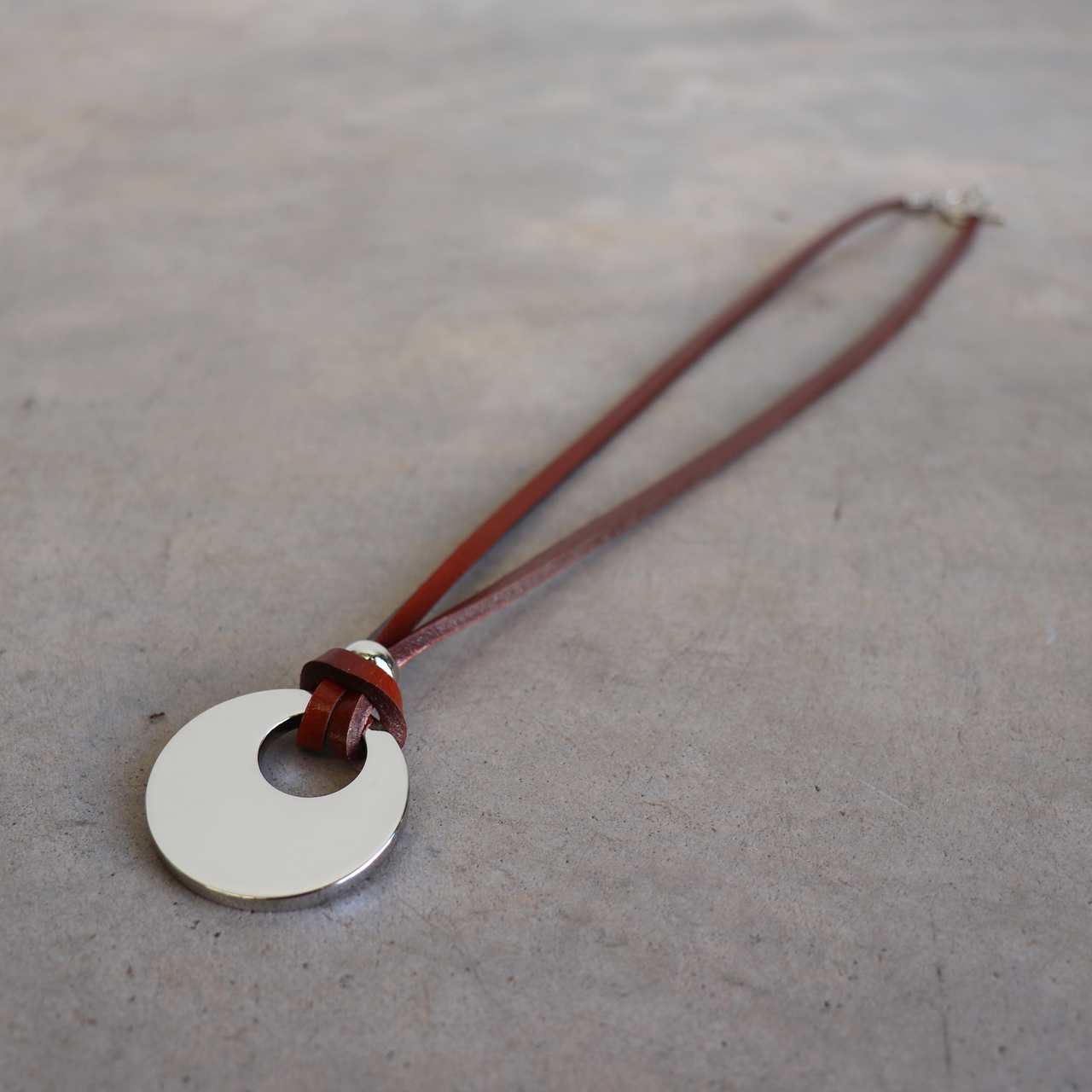 Silver Moon-shaped pendant combined with a natural leather band, available in 3 colours, Black, Silver and Tan.