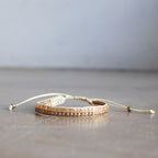 Classic art deco styling, featuring two rows of fine brass and glass beads all hand-knotted using traditional ethnic techniques. Gold & Champagne.