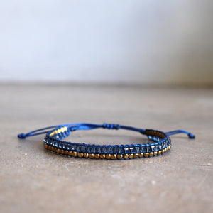 Classic art deco styling, featuring two rows of fine brass and glass beads all hand-knotted using traditional ethnic techniques. Gold & Royal Blue.