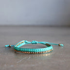 Classic art deco styling, featuring two rows of fine brass and glass beads all hand-knotted using traditional ethnic techniques. Gold & Turquoise. 