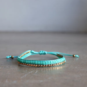 Classic art deco styling, featuring two rows of fine brass and glass beads all hand-knotted using traditional ethnic techniques. Gold & Turquoise. 