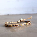 Handmade bracelet with fine metallic beads. Two colour options for stacking or individual wearing. Button style closure with 3 size options. Beige/Mix.