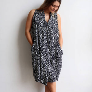 Origami Dress in floral print is a sleeveless trapeze sundress in black or navy blue. Pockets view.