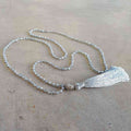 Glass faceted beads with metallic finish. Silver plated Buddha bead charm at centre with long, silky soft tassel. SILVER