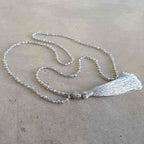 Glass faceted beads with metallic finish. Silver plated Buddha bead charm at centre with long, silky soft tassel. SILVER