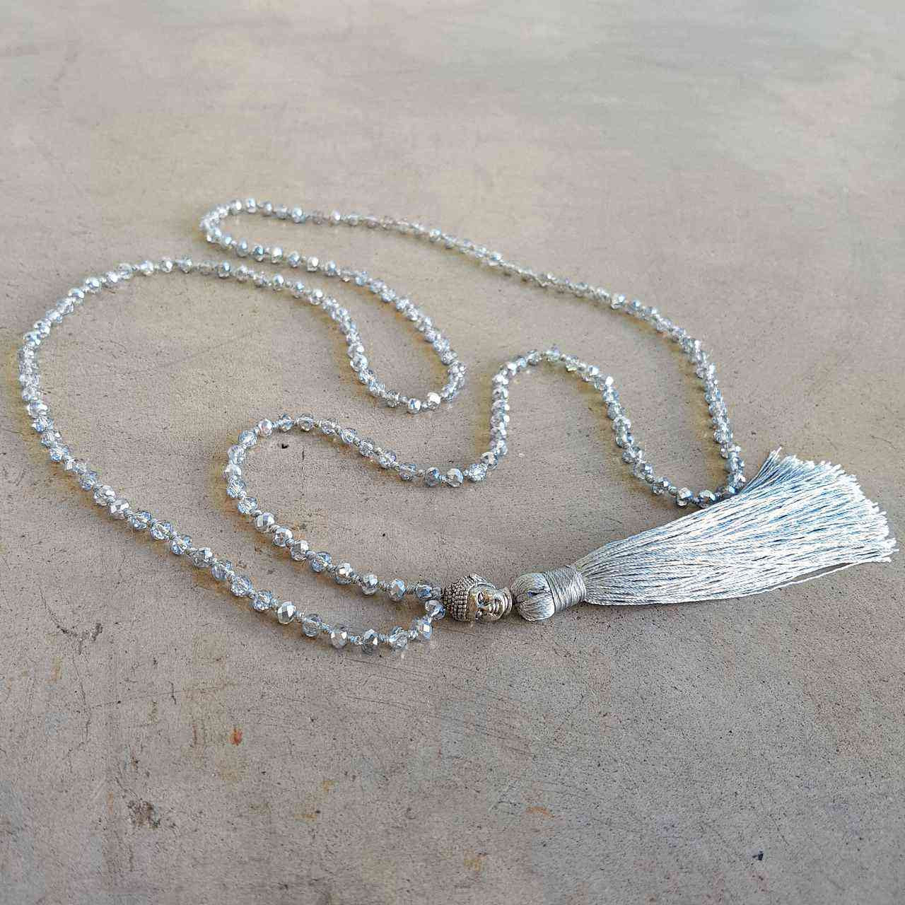 Glass faceted beads with metallic finish. Silver plated Buddha bead charm at centre with long, silky soft tassel. SILVER