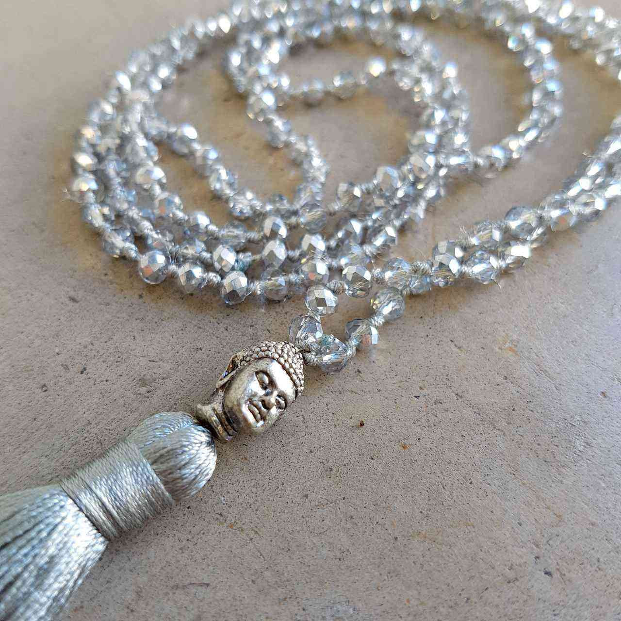 Glass faceted beads with metallic finish. Silver plated Buddha bead charm at centre with long, silky soft tassel. SILVER