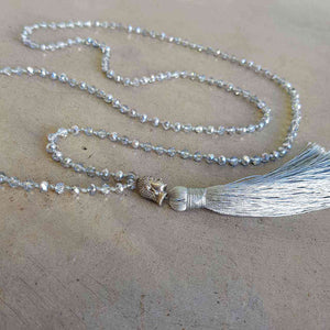 Glass faceted beads with metallic finish. Silver plated Buddha bead charm at centre with long, silky soft tassel. SILVER