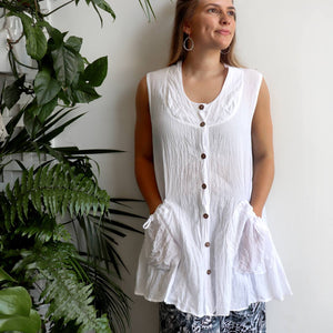 Take It Easy women's button-through sleeveless tunic top. Perfect summer travel shirt made from 100% cotton with handy side pockets. Sizes S/M-L/XL. White.