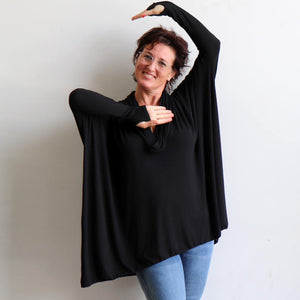 Our Glider Poncho Tee made in bamboo is a cowl neck plus size winter kaftan top. Black. Hands view.