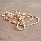 Freshwater pearls and cut glass beads. Hand knotted. 155cm full length. Champagne.